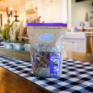 A bag of organic pecans sits on a kitchen table.