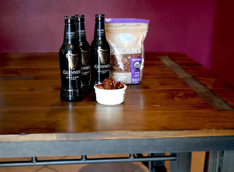 Guinness Beer Pecans surrounded by Guinness Stout bottles and Glenda's Farmhouse Pecans