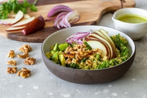 A walnut pear avocado bowl surrounded by it's fresh ingredients.