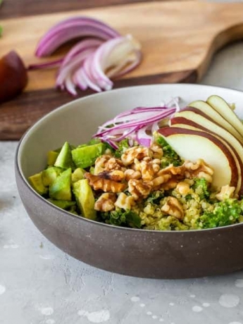 A walnut pear avocado bowl surrounded by it's fresh ingredients.