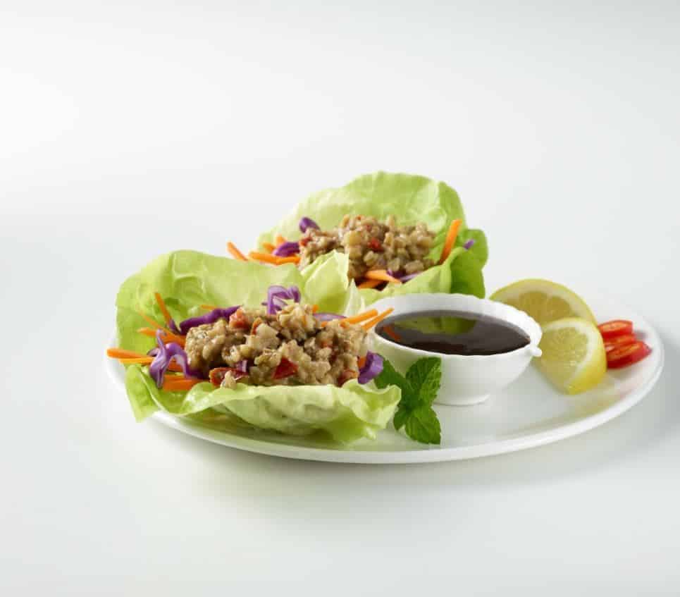 Asian Spiced Walnut Crumbles on butter lettuce with dip, lemon wedges, and hot chilis.