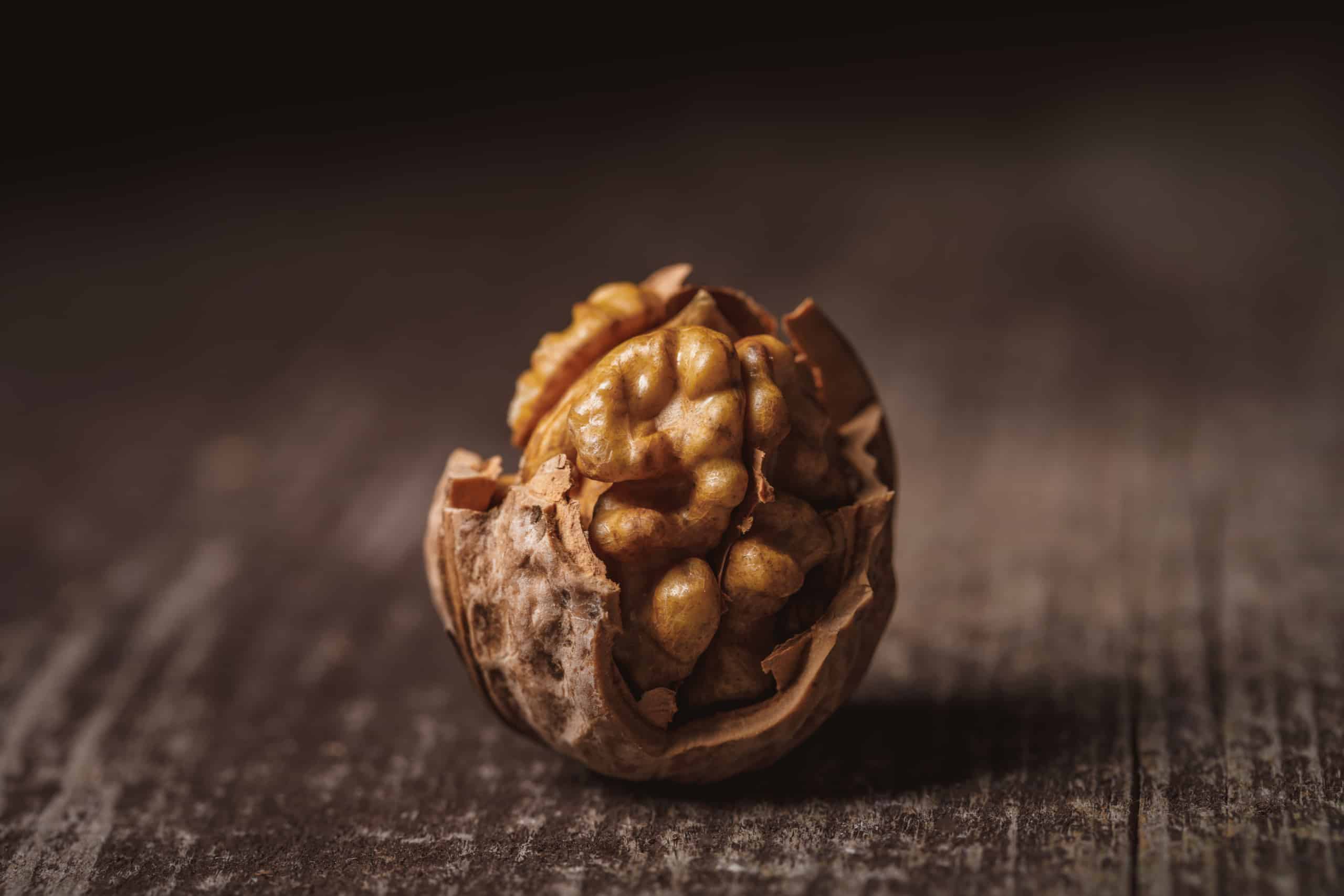 This beauty of a half opened walnut sits on a wooden table in our Walnut Calories blog post.